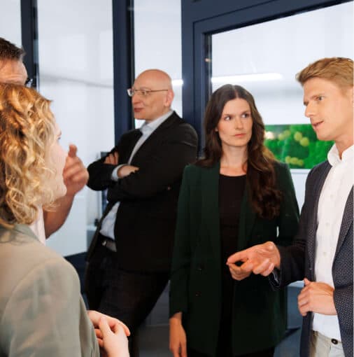 Kleine Gruppe diskutiert stehend in einem Büro