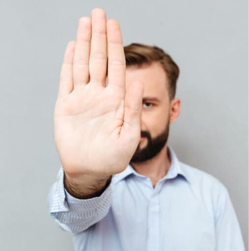 Mann hält abwehrend die Hand in Richtung Kamera