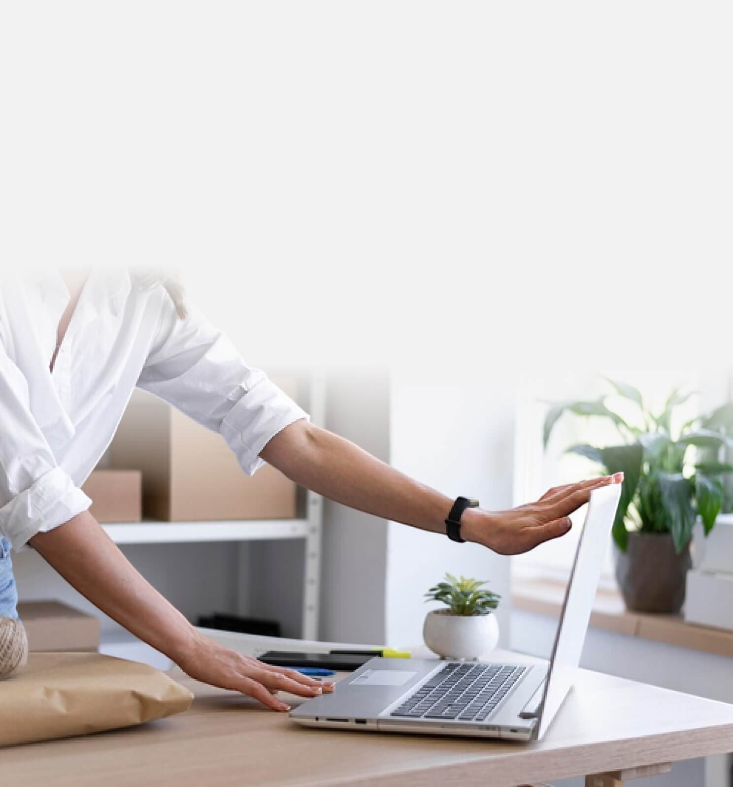 Person zeigt am Schreibtisch auf einen Laptop