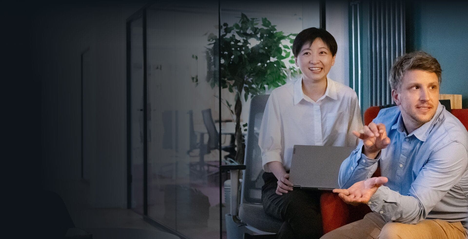 Beraterin mit Laptop und gestikulierender Berater im Gespräch über ein Change-Management-Vorhaben