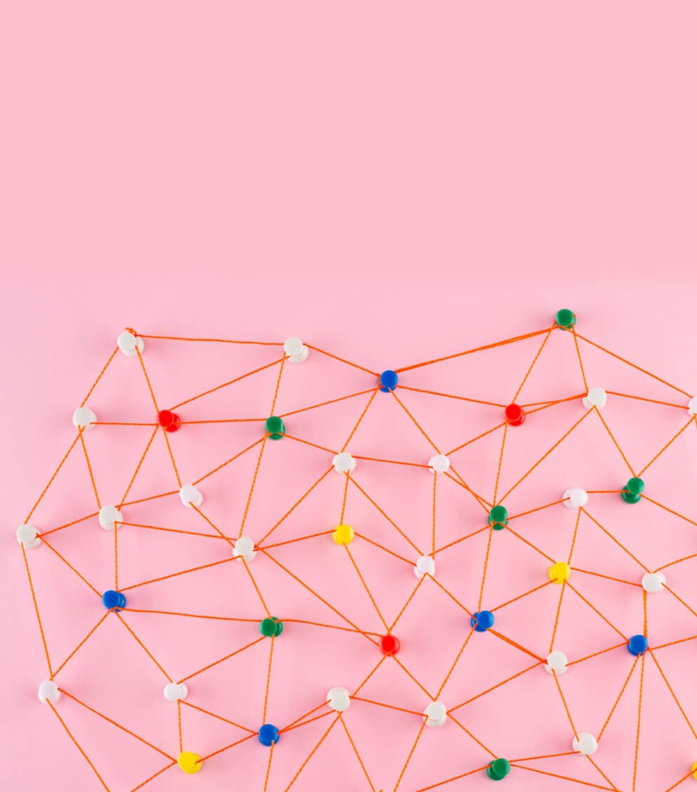 Bunte Pinnnadeln, durch orangefarbene Fäden zu einem Netzwerk verbunden