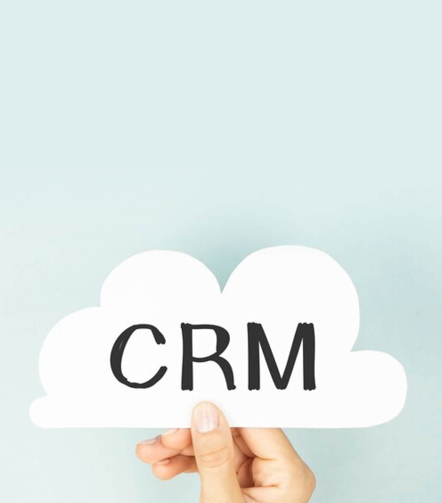 Hand hält ein Wolkenschild mit der Aufschrift CRM